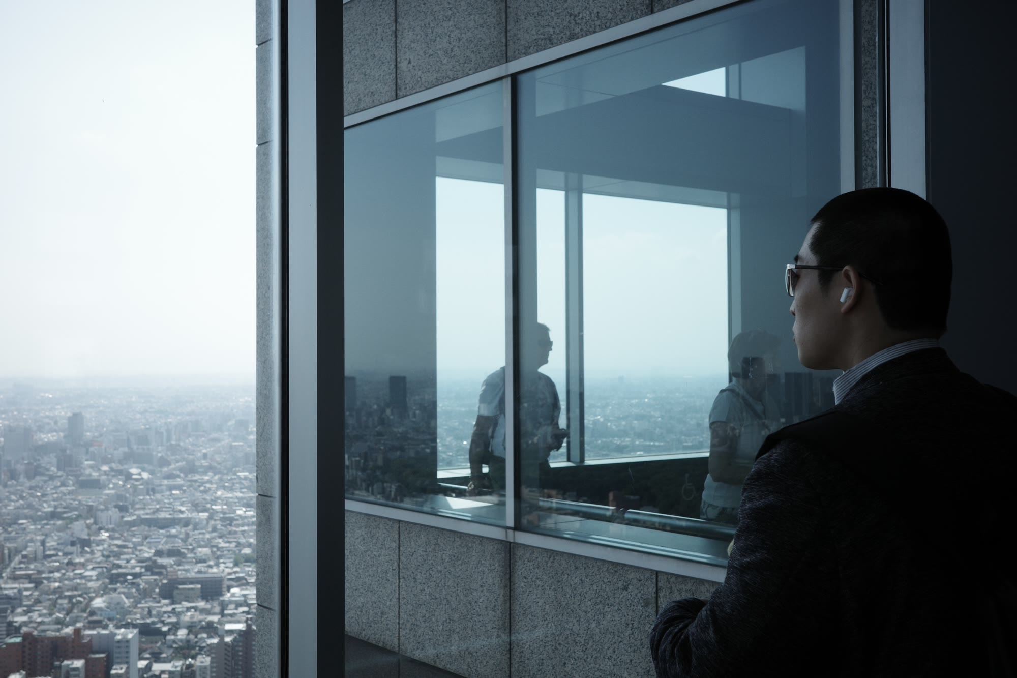 A visitor looking over Tokyo from a high-rise observation deck.